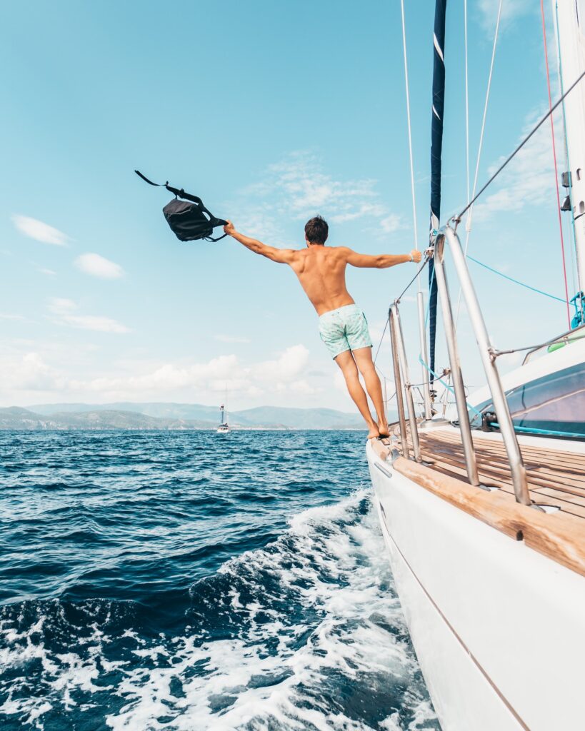 להפליג ביוון - איש עומד על  הסיפון ונהנה מהים